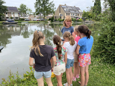 Rosan geeft uitleg aan een groepje schoolkinderen dat bij de metingen kwam kijken